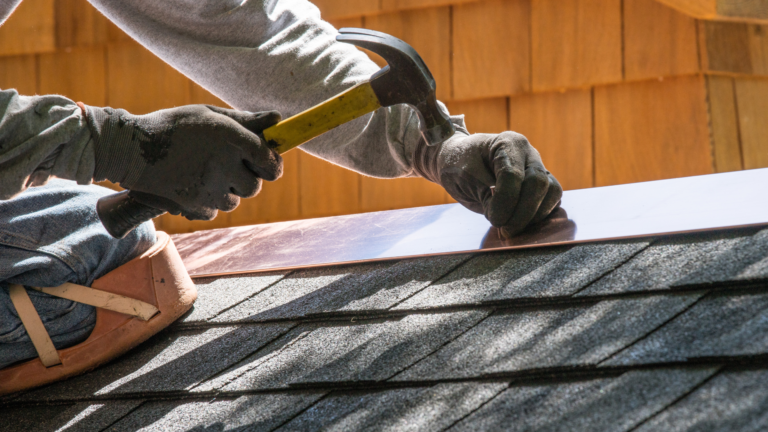 Roof repair service in Footscray, Victoria, with a tradesperson securing metal flashing along a residential shingle roof.