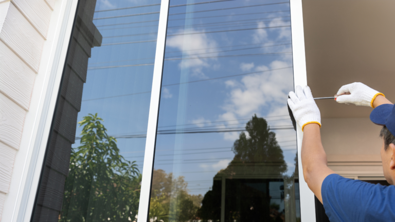 Window repair service in St Kilda, Victoria, with a technician adjusting and securing the frame of a large residential glass window.
