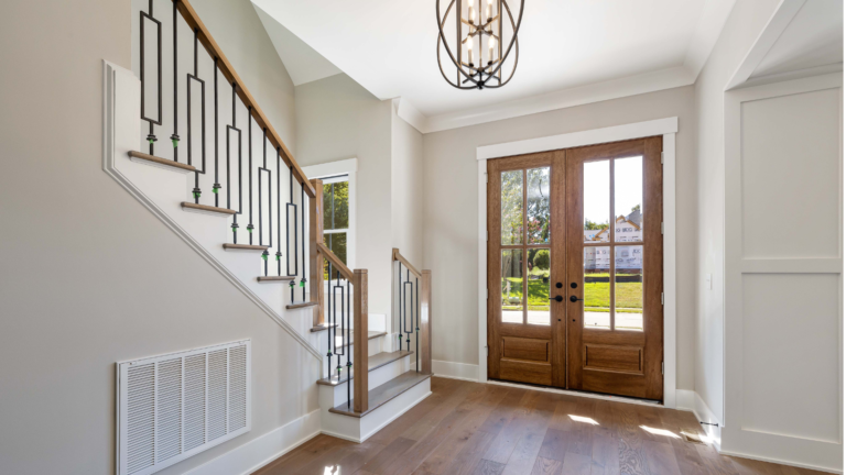 Completed door installation in Elwood, Victoria, featuring timber double entry doors with glass panels in a newly finished residential foyer.