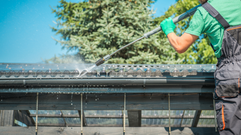Gutter cleaning service in Prahran, Victoria, with a professional pressure-washing a residential roof and gutter to remove dirt, debris and buildup.